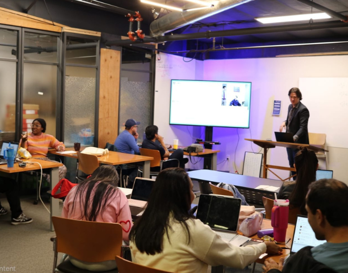 Students sitting together on a bench with their arms around each other.